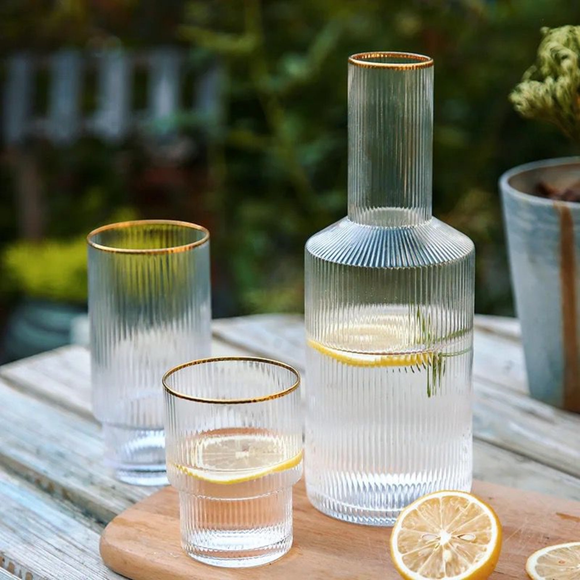 Izmir gold rim ripple glass carafe and glasses set on a table in the garden